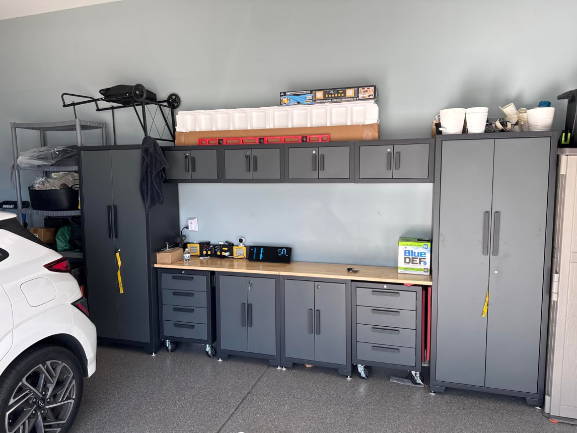 A real garage storage system installed: cabinets, workbench, and wall organization working together